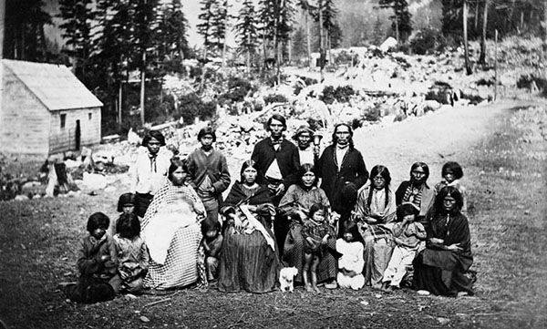 Group of Indigenous people at Boston Bar wearing a mix of traditional and victorian clothing, circa 1860s.